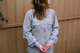 model wearing repurposed grey shirt with pale blue stripe, square neckline and patch pockets