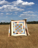 Housetop quilt with checkered centre, made with blue, yellow pink and brown reclaimed fabrics. Made in Naarm / Melbourne by Britta Rouse