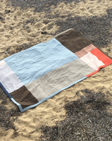 Simple quilt made from blue, brown, lilac, orange and pink reclaimed fabrics. Hand made in Naarm / Melbourne by Britta Rouse